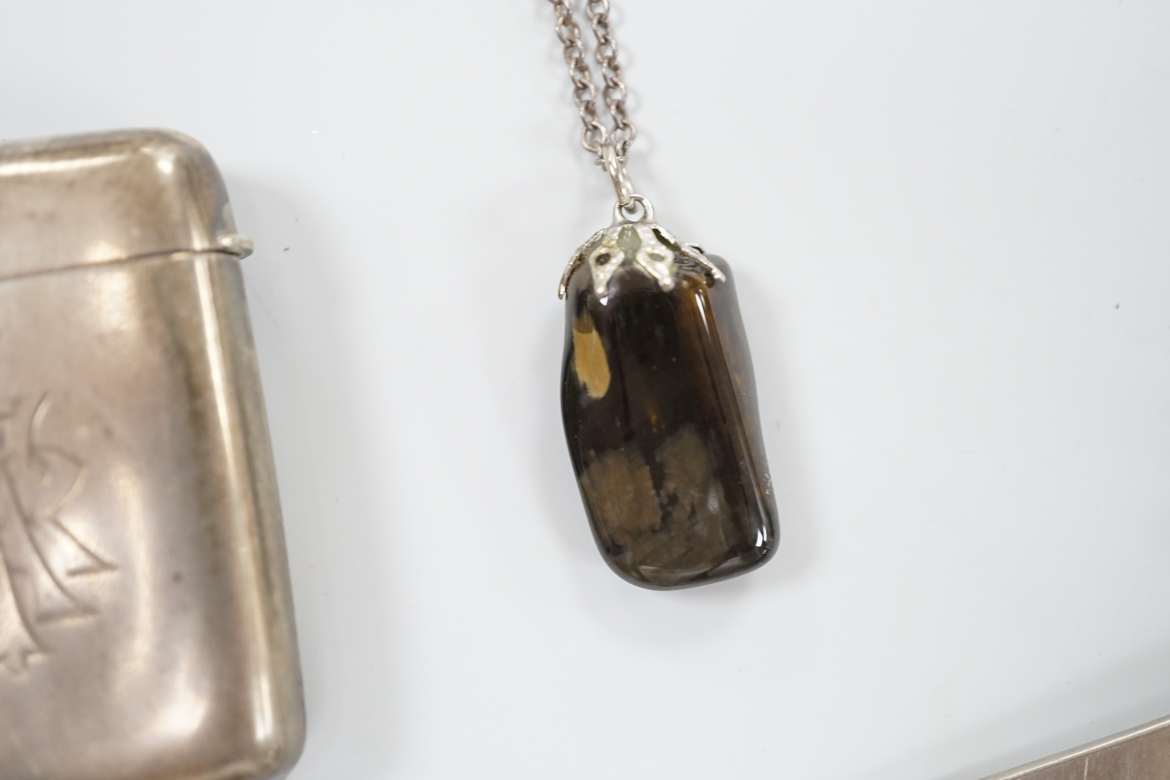 A late Victorian silver and hardstone Scottish dirk brooch, 11.75cm, an Edwardian silver vesta case, a white metal belt buckle, a hardstone pendant, a gilt metal Egyptian theme bracelet and a miniature steel sword